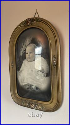 This is a vintage framed photograph of a baby with a convex glass